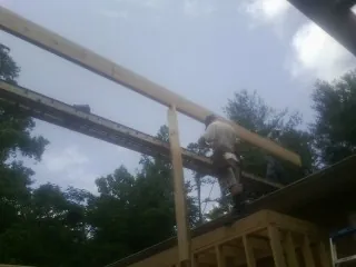 Carpenter setting a ridge beam over a new addition frame — Ice Dam Removal by Roofing Brothers in Inman